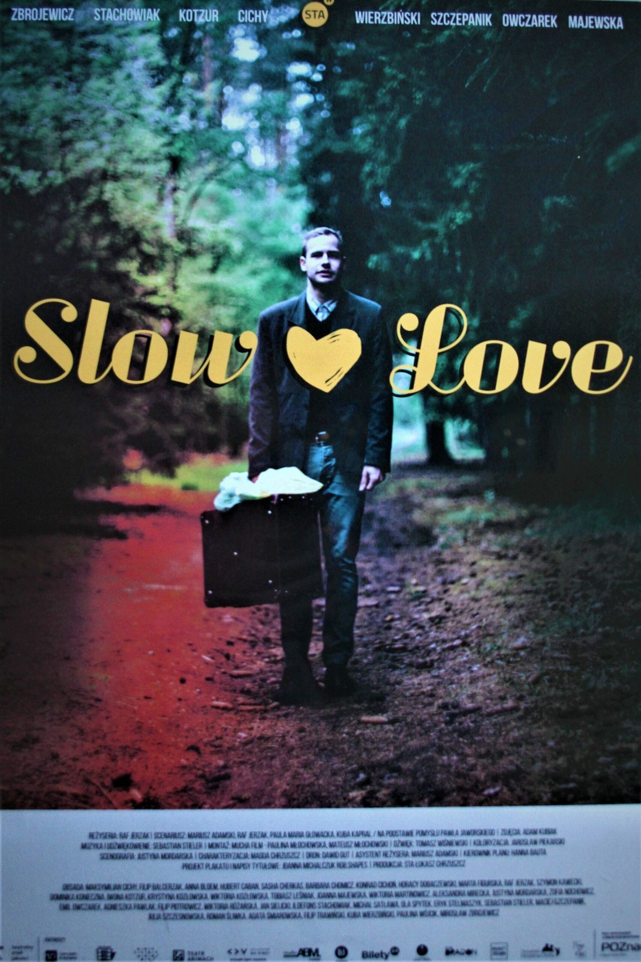 Movie poster of 'Slow Love' with a person walking on a wooded path carrying a suitcase.
